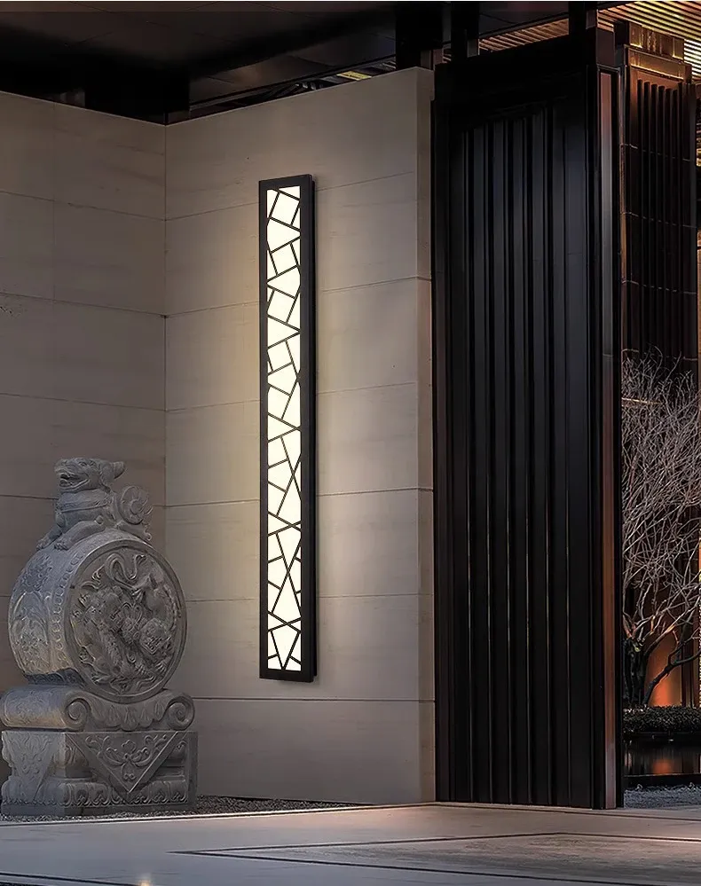 מנורת קיר ליד פסל אבן בכניסה מעוצבת