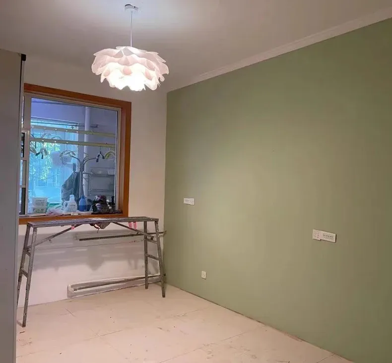 מנורת תלייה בעיצוב מודרני בחדר עם קיר ירוק וסולם