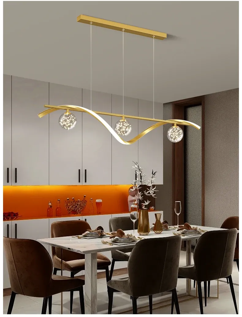 מנורת תלייה זהובה מעל שולחן אוכל עם כיסאות חומים