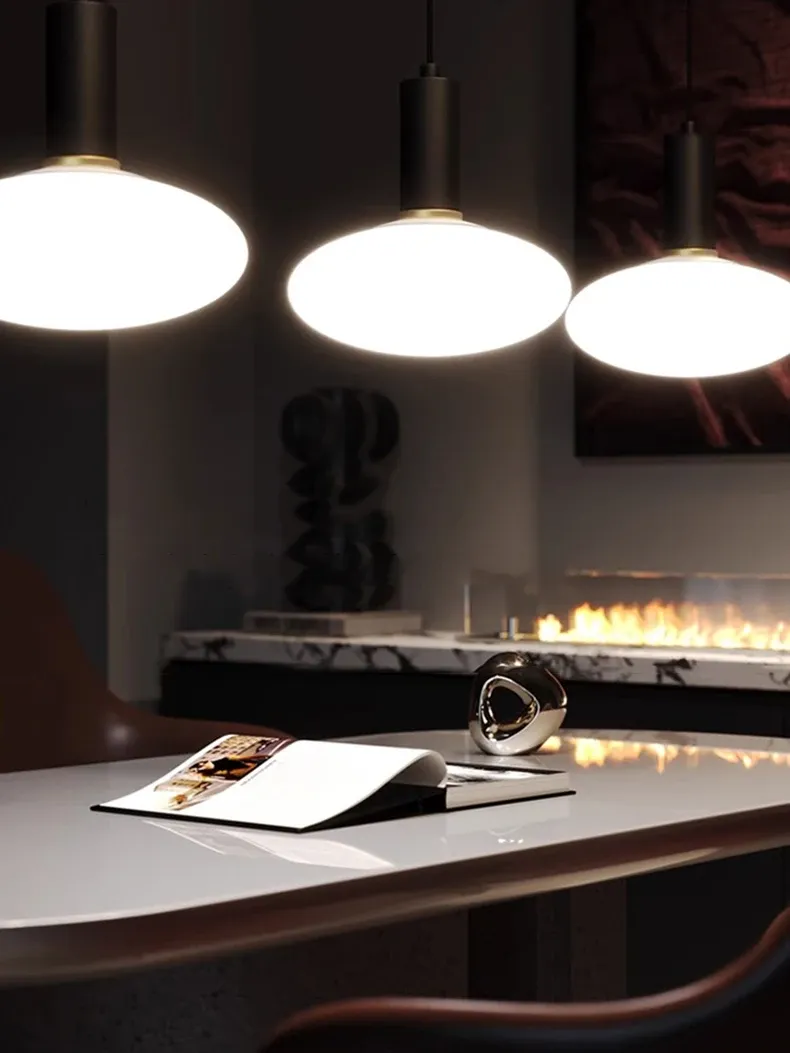 מנורות תלויות מעל שולחן עם פסל מודרני ואח