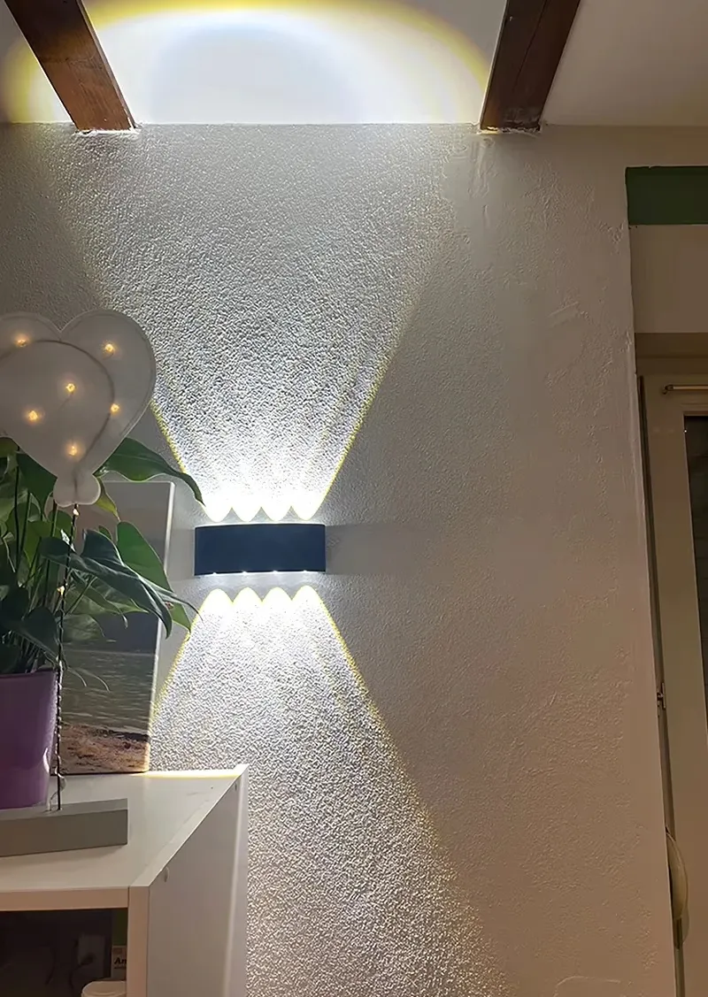 מנורת קיר שחורה עם תאורה חזקה על קיר לבן