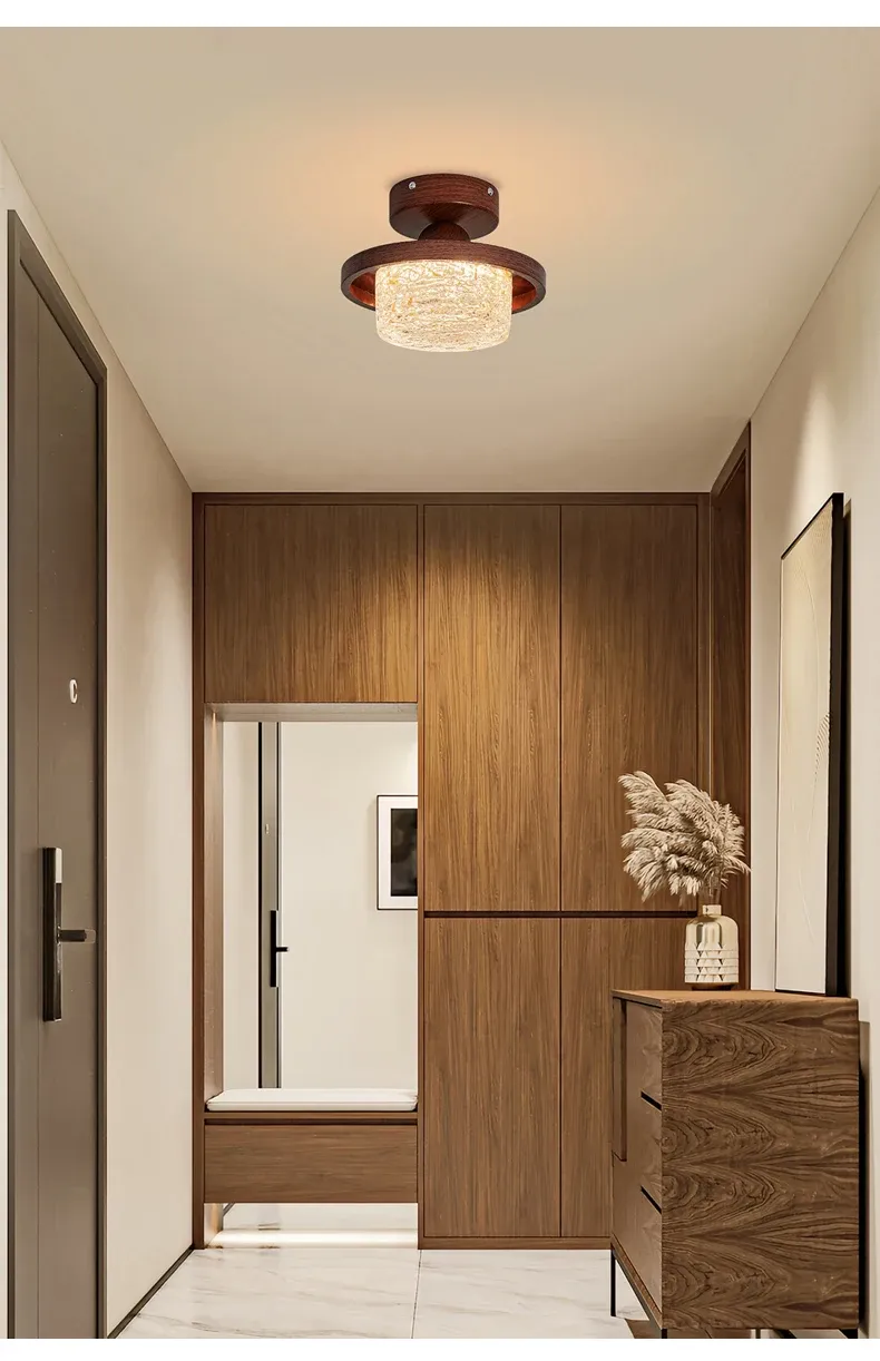 גוף תאורה בתקרה מעל ארון עץ במסדרון