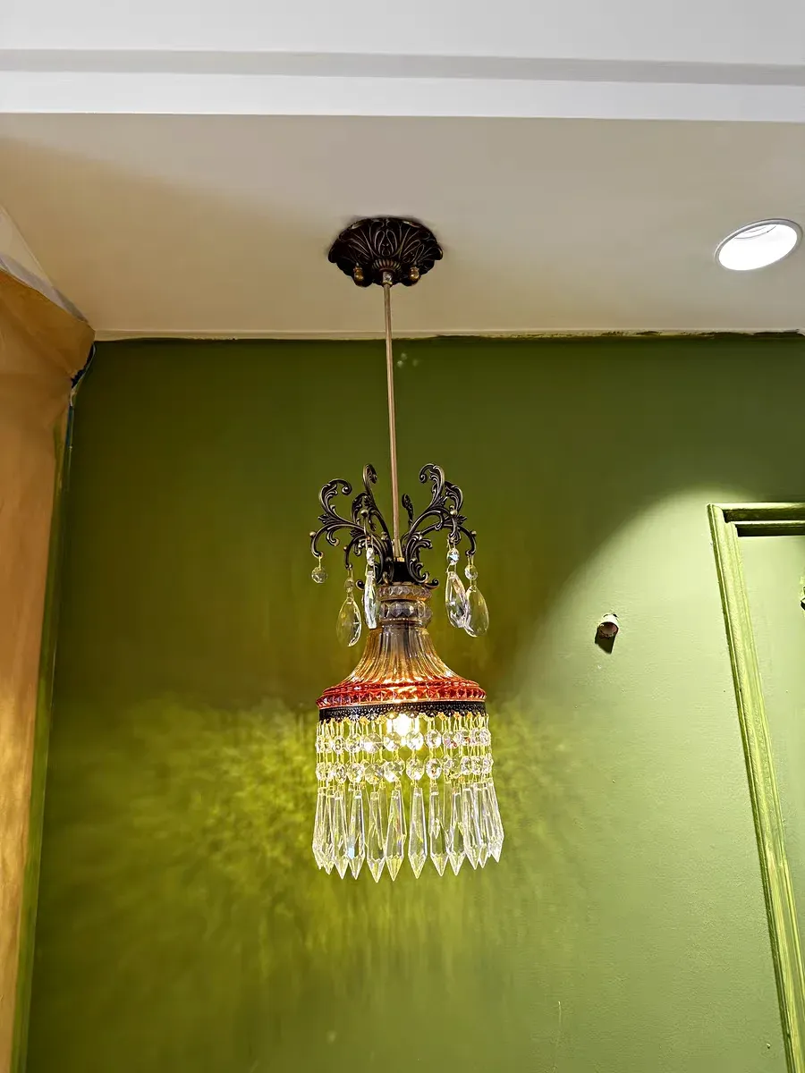 נברשת קריסטל קטנה תלויה על תקרה ירוקה