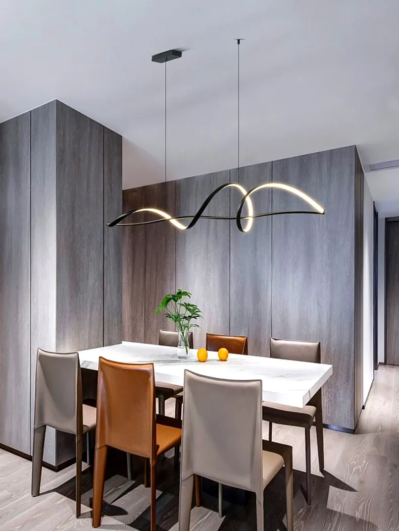 מנורת תלייה שחורה מעל שולחן אוכל עם כיסאות צבעוניים