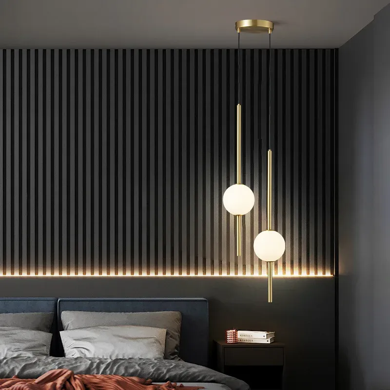 מנורות תלייה עם כדורי זכוכית ומוטות זהב בחדר שינה מעוצב