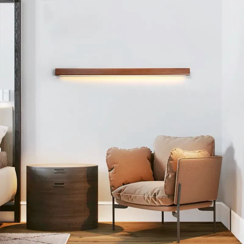 גוף תאורה אופקי מעל כורסה ושולחן עגול