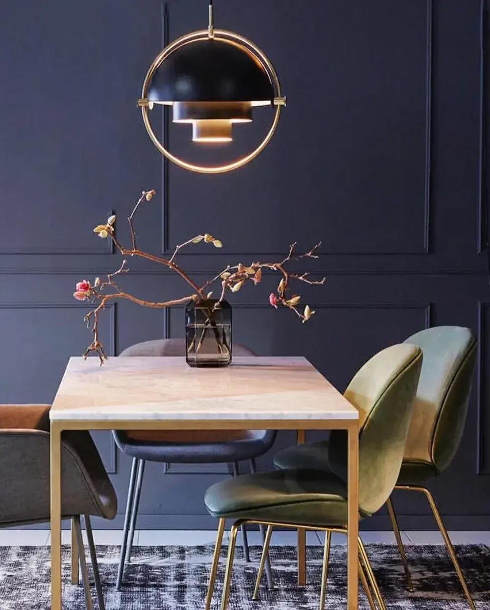 מנורה שחורה מעל שולחן עם כיסאות צבעוניים וקיר כחול