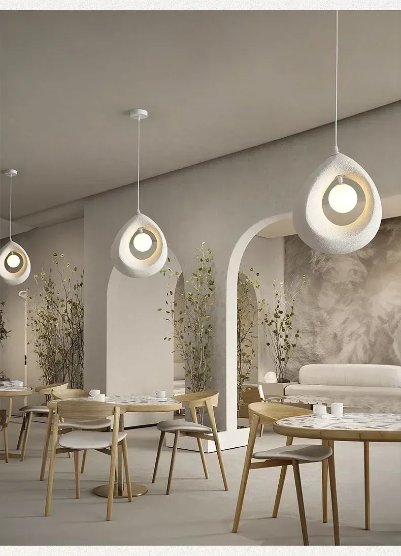 מנורות תלייה מעל שולחנות עץ בחדר אוכל מעוצב