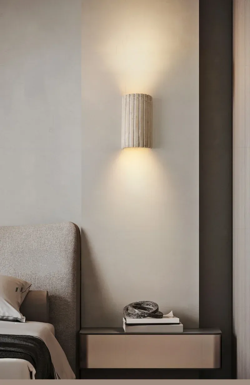 מנורת קיר מעל שידה ליד מיטה עם מצעים אפורים