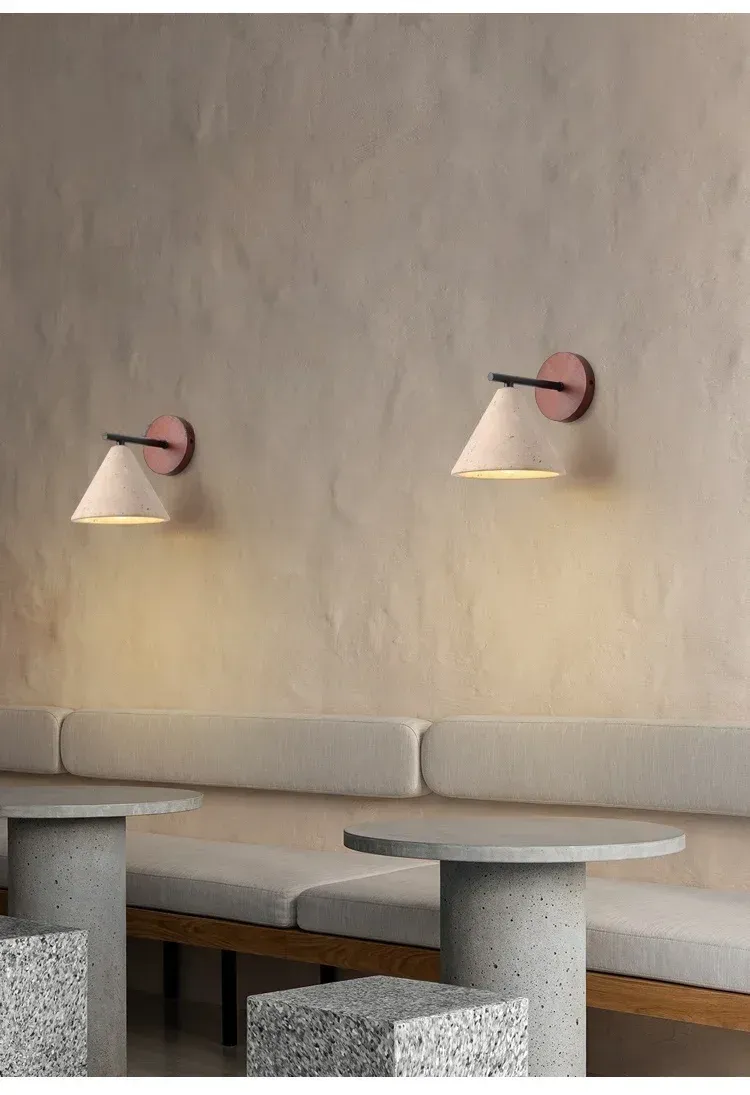 שתי מנורות קיר על קיר בטון מעל ספות