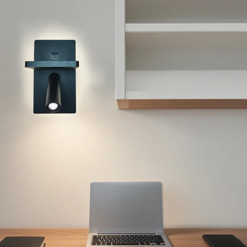 מנורת קיר שחורה מעל שולחן עם מחשב נייד