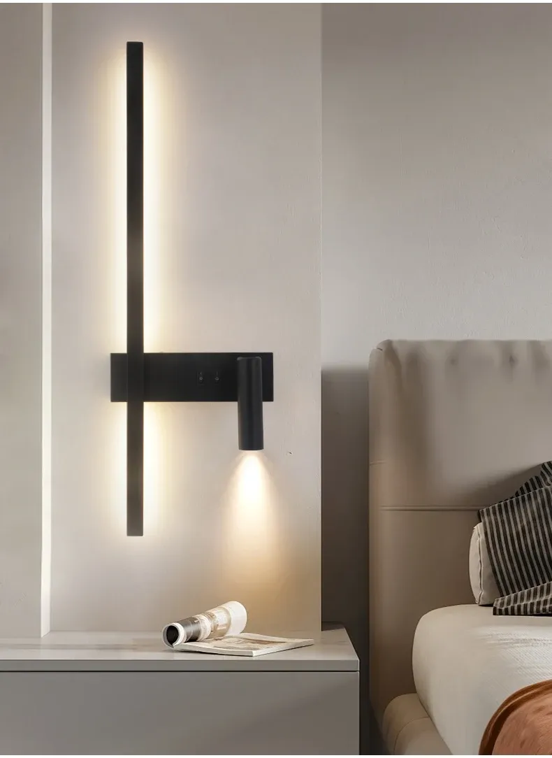 תאורה מודרנית על קיר ליד מיטה עם עיתון