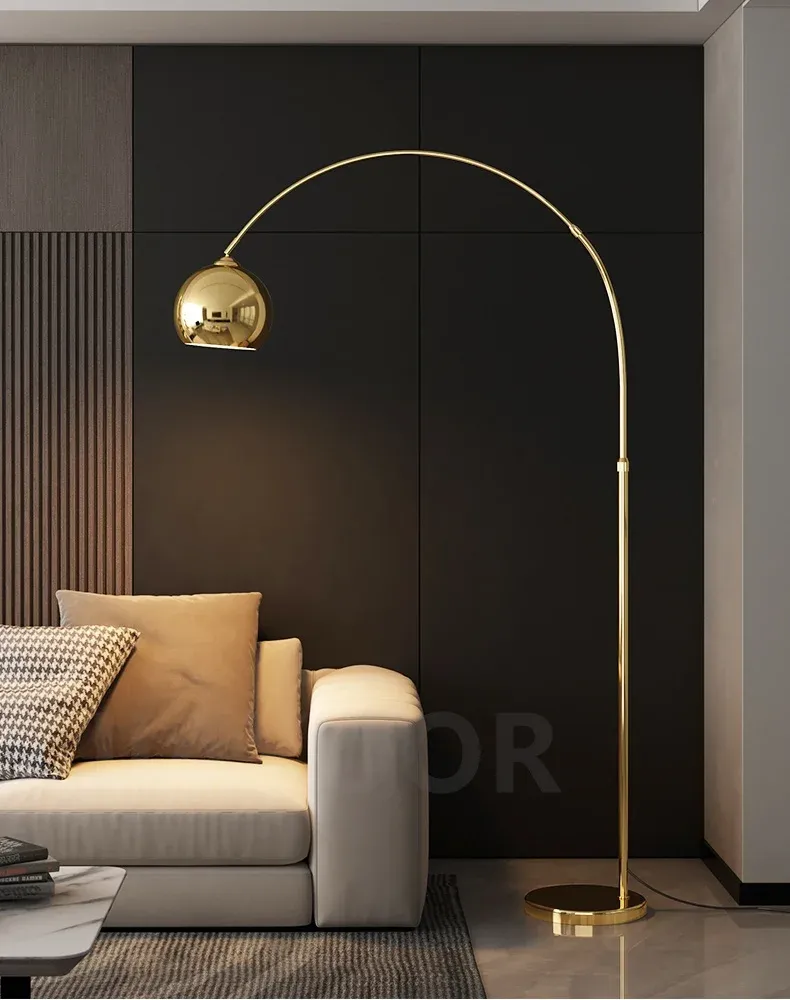 מנורה זהובה ליד ספה לבנה עם כריות אפורות