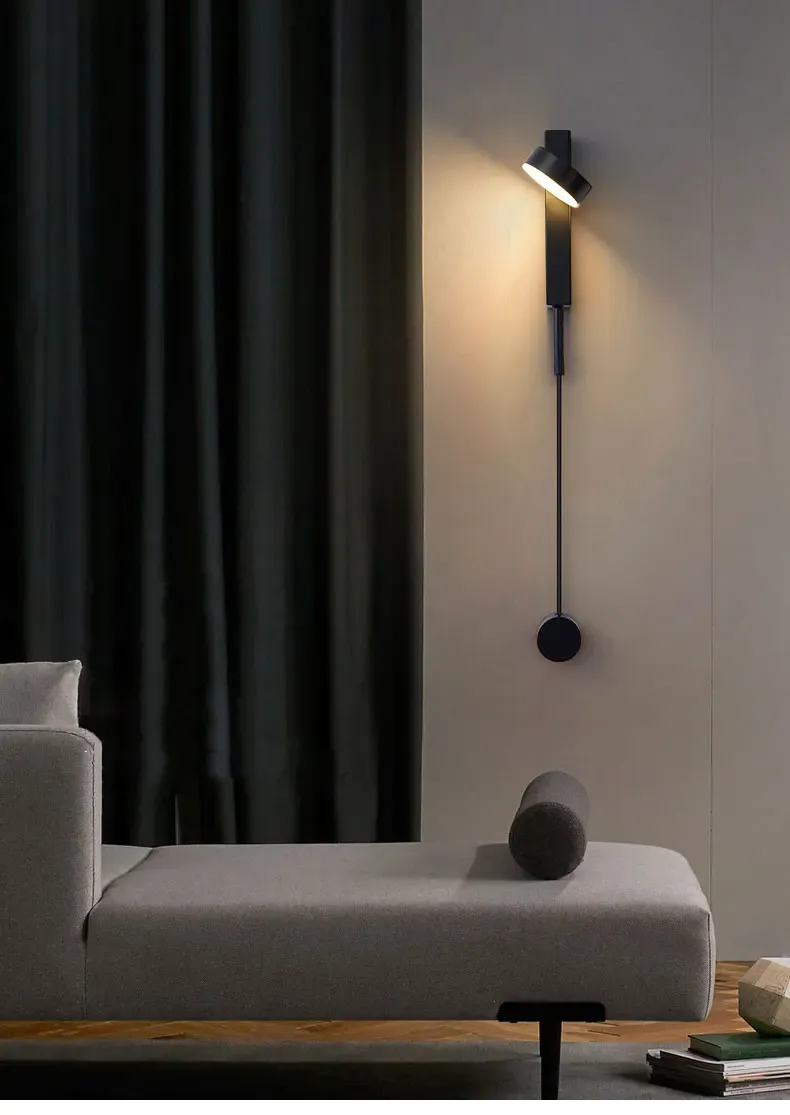 מנורת קיר מודרנית מעל ספה אפורה כהה