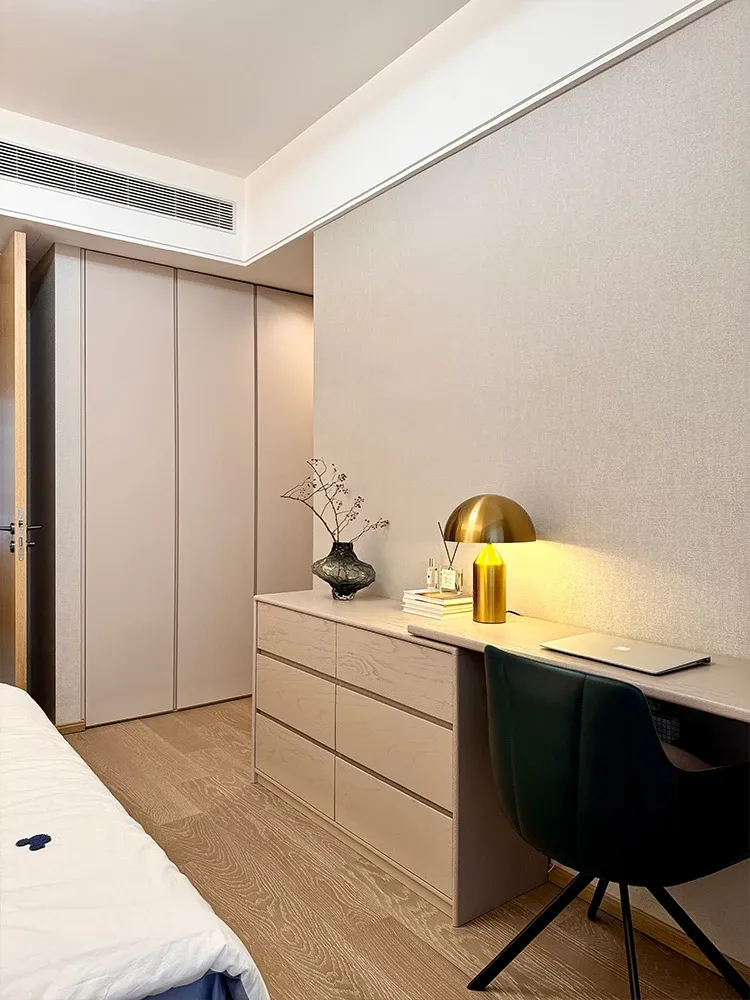 חדר שינה עם מנורת שולחן זהב ושידה מעץ