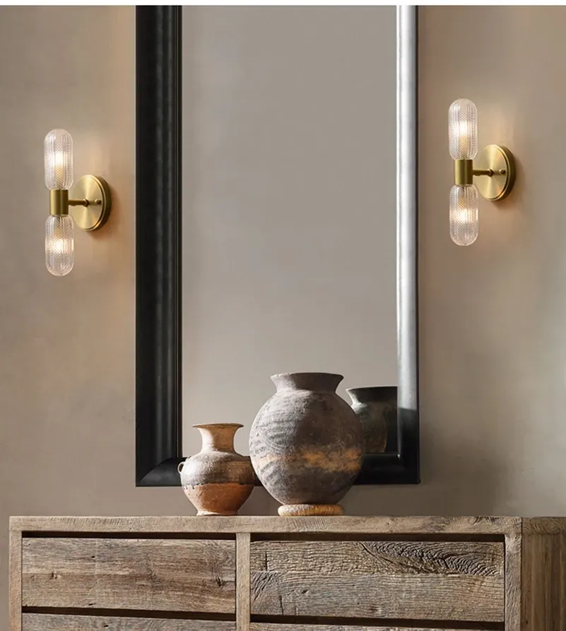 מנורות קיר ליד מראה גדולה וחפצי חרס