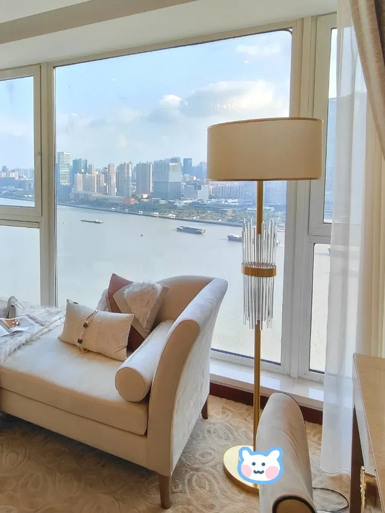 מנורת רצפה קריסטל ליד חלון עם נוף לעיר